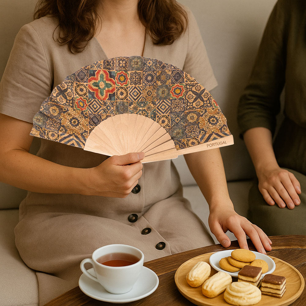 A LADY HAVING AFTERNOON TEA WITH FRIEND, USING A CORK FAN